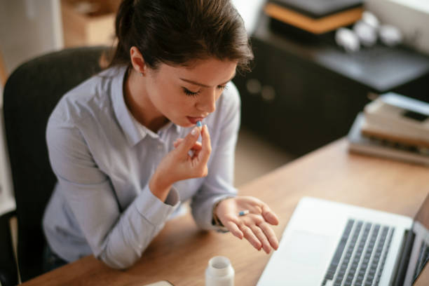 istock Young businesswoman drinking medicine pill. 1292942371