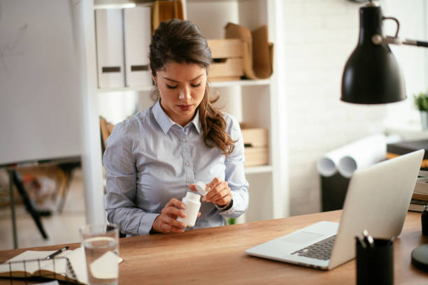 istock Young businesswoman drinking medicine pill. 1292942807
