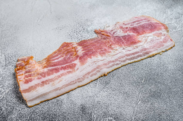 istock Smoked sliced pork bacon ready for cooking. White background. Top view 1292943703