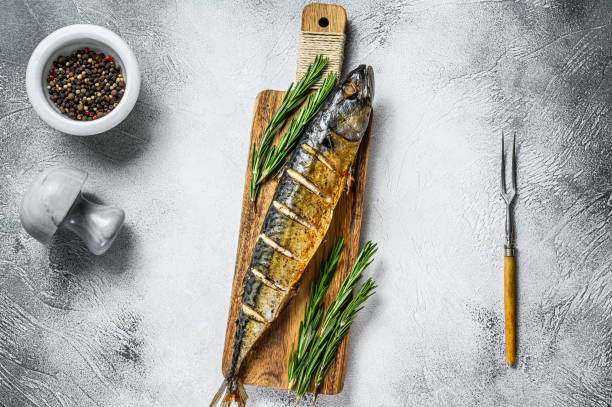 istock Oven baked whole mackerel fish with herbs. White background. Top view 1292944630
