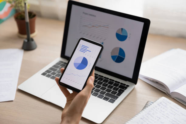 istock Close up businesswoman holding working with project statistics on devices 1292945673