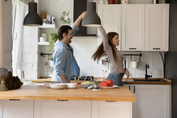 istock Happy young wife and husband dancing in kitchen, celebrating event 1292945725