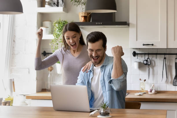 istock Overjoyed couple looking at laptop screen, celebrating success 1292945764