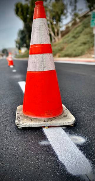 istock traffic cone on wet painted street lines 1292949065