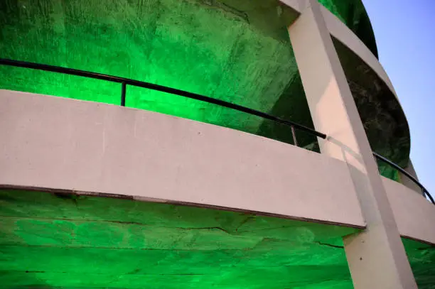 Glowing green circular concrete parking structure