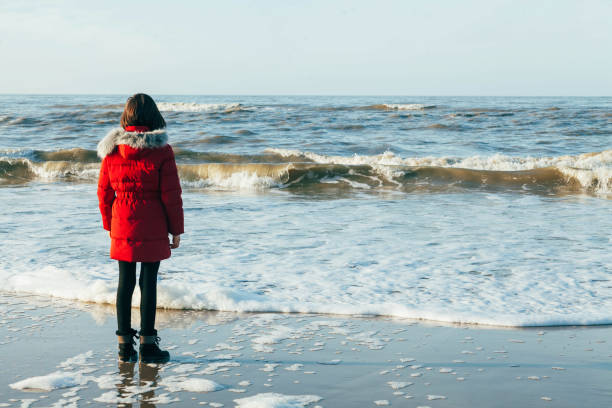 12 years old child having fun on the beach - teenage kid playing during winter time outdoor - 10 11 years cheerful happiness fun imagens e fotografias de stock