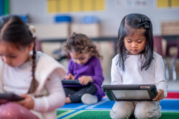 istock Young asian female preschool student looking at tablet computer 1292968426