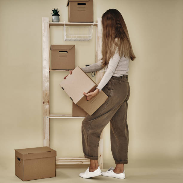 istock The girl makes up paper boxes on a wooden rack. Eco-friendly storage and packaging 1292968430
