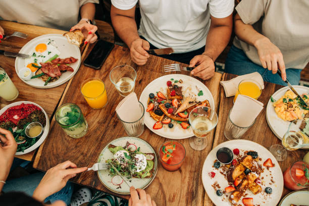 카페의 테이블에서 아침 식사 또는 브런치를 먹는 사람들의 그룹 - waffle eating meal food and drink 뉴스 사진 이미지