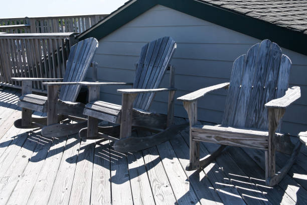 istock Three wood adirondack chairs sitting on a deck 1292977623