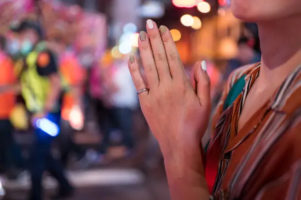 Photo of Detail of hands of Asian girl praying during Ghost Festival Taoist religious celebration in the streets of Hsinchu