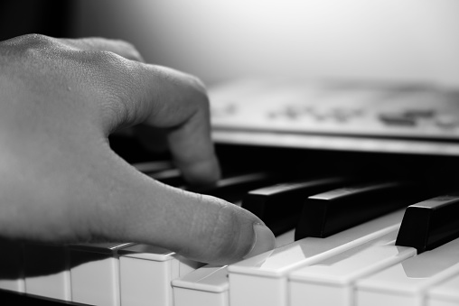 Close up of hand playing piano