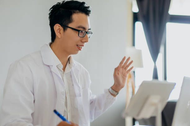 istock Asian doctor using digital tablet for online meeting 1292991769