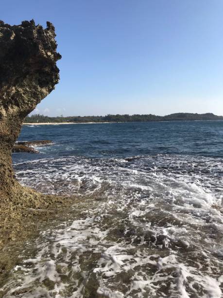 crystal clear blue beach waves with rock formation - 2127 imagens e fotografias de stock
