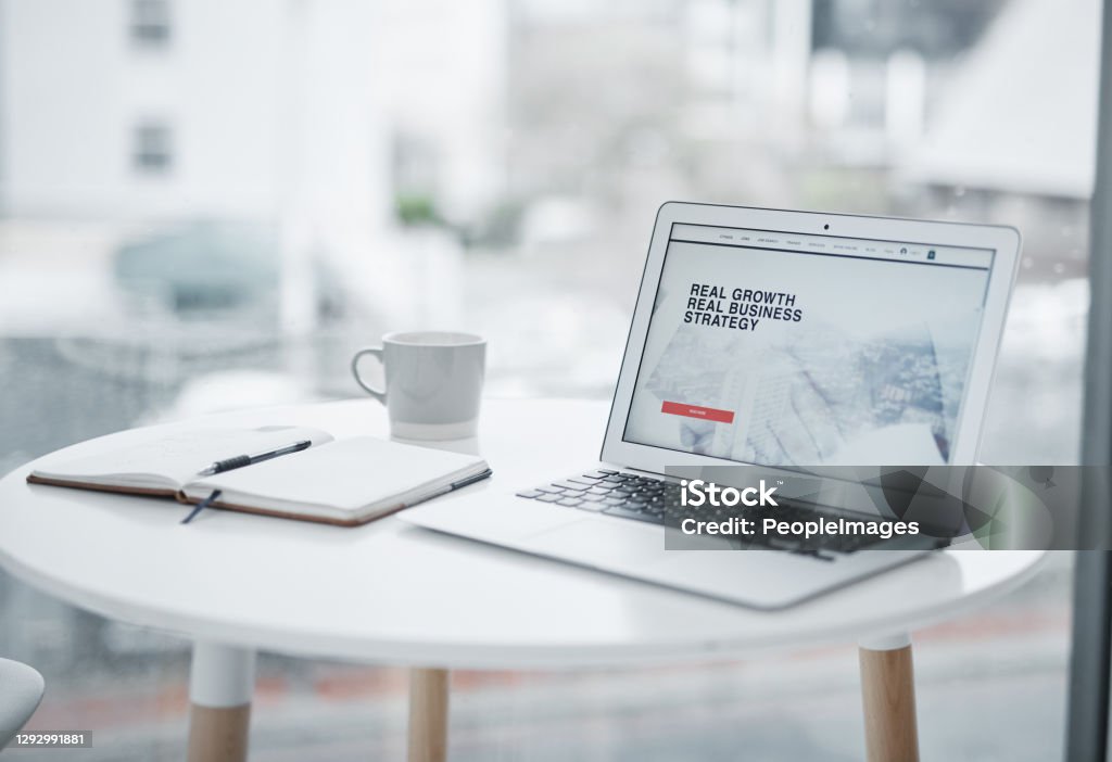 The more you know the more your business grows Shot of a laptop displaying a business related website on a table at home Web Page Stock Photo
