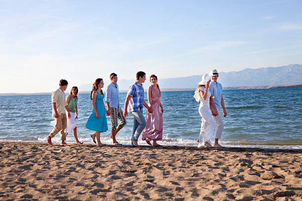 couple de jeunes mariés sur la plage avec vos amis - wedding suit photos et images de collection