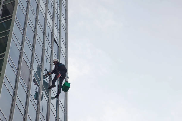 istock Industrial mountaineering worker hangs over residential building while washing exterior facade glazing 1293002401
