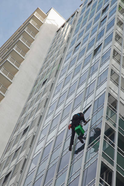 istock Industrial mountaineering worker hangs over residential building while washing exterior facade glazing 1293002411