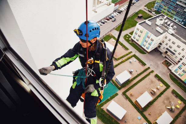 istock Industrial mountaineering worker hangs over residential building while washing exterior facade glazing 1293002420
