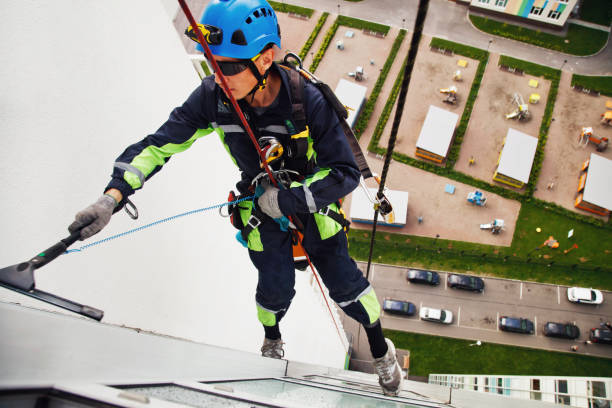 istock Industrial mountaineering worker hangs over residential building while washing exterior facade glazing 1293002434