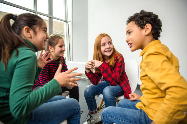 istock Group of children smiling and talking in a group session 1293003216