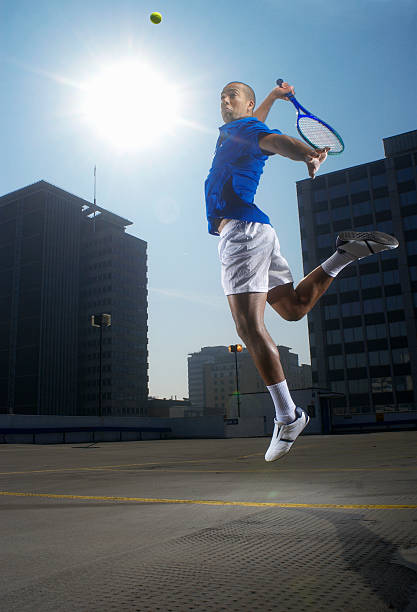 теннисный игрок прыжки на корт на крыше - tennis serving men court стоковые фото и изображения