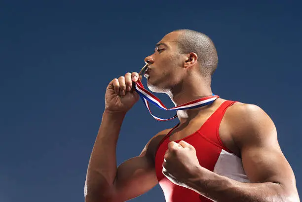 Photo of Athlete kissing medal outdoors