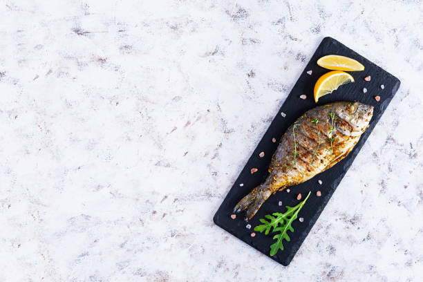 istock Grilled dorado fish on white background. Roasted seafish with spice and herbs 1293005793