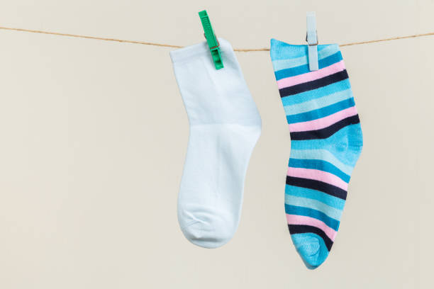 istock multicolored socks, dry after washing, hanging on a clothesline with clothespins on a light background 1293008112