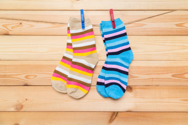 istock multicolored socks hanging on a clothesline with clothespins on a wooden background 1293008189