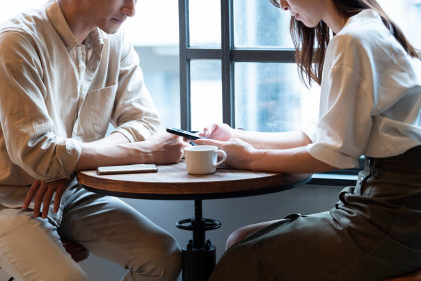 A couple having a fun conversation at a cafe A couple having a fun conversation at a cafe men close up 20s asian ethnicity stock pictures, royalty-free photos & images