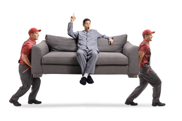 istock Movers carrying a sofa with a young man in pajamas 1293014658