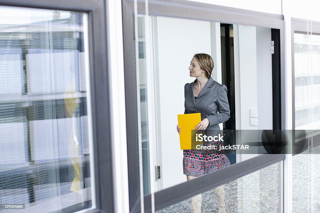 Femme d'affaires portant le dossier dans le bureau - Photo de 30-34 ans libre de droits