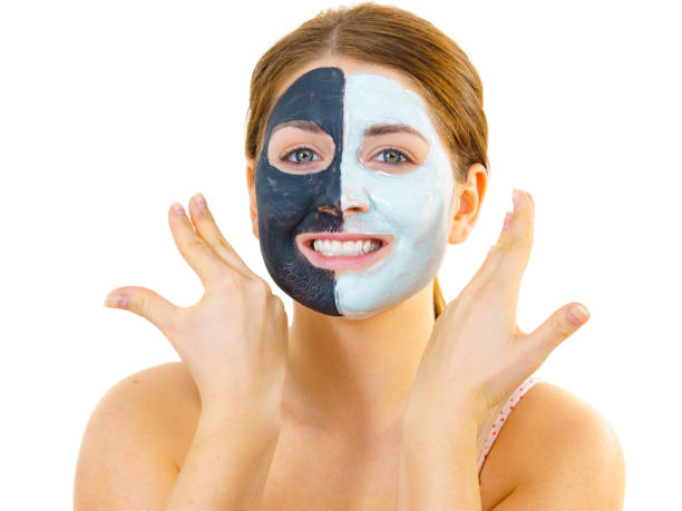 istock Girl with black white mud mask on face 1293021613