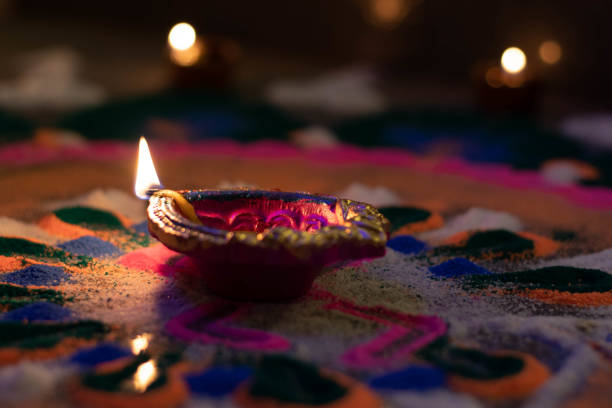 istock Bright Colorful Earthen Clay Lamp Diya Or Deep With Golden Yellow Flame Placed On Beautiful Rangoli Shot At Dark Black Night Hours During Deepawali Happy New Year Festival Celebration With Blur Bokeh Light In The background 1293023548