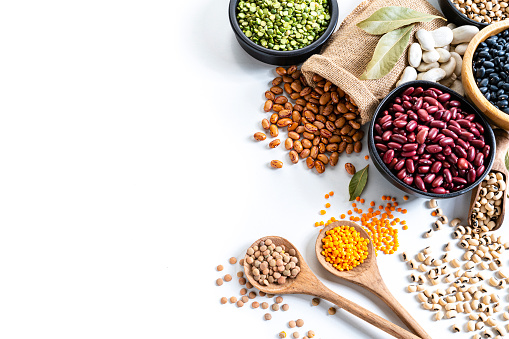 Different types of legumes in bowls, yellow and green peas, mung beans and chickpeas , colored beans and lentils, top view, copy space