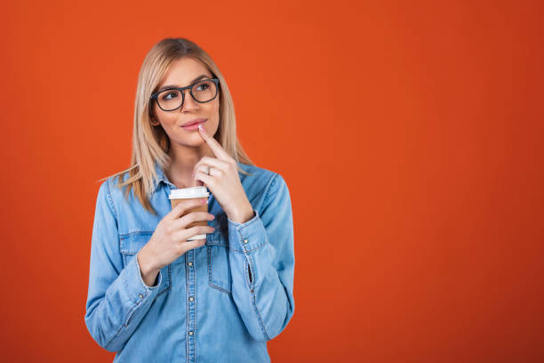 istock Woman holding coffee cup while thinking and looking away. 1293024393