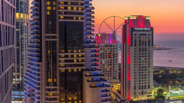 JBR and Bluewaters island after sunset aerial day to night transition timelapse. Modern towers and skyscrapers, traffic on the bridge