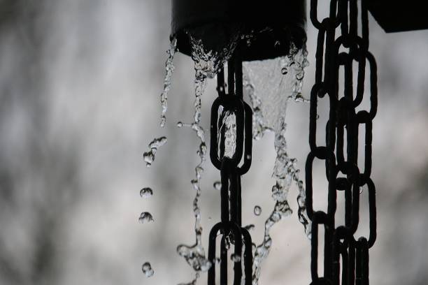 many rainwater falls from the rain gutter onto the ground via a chain