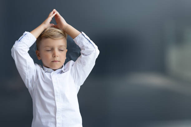 istock Small boy doing Yoga breathing exercises with eyes closed. 1293026992