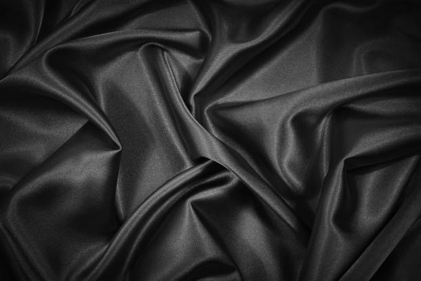 istock Abstract black background. Black silk satin fabric texture background. Beautiful soft folds on shiny fabric. Black elegant background for your design. 1293028909