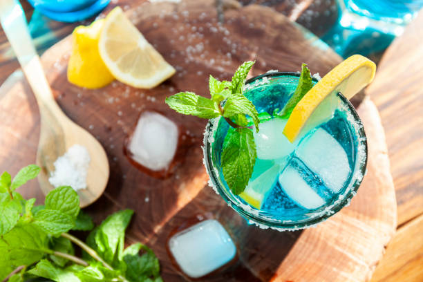 istock Alcoholic cocktail on a wooden table surrounded by ingredients such as lemon, salt, sugar, ice 1293030121