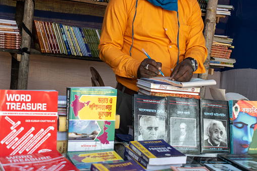 Katwa, West Bengal, India - December 19, 2020; image of the bookstall in a book fair where the seller is waiting for the buyer by arranging the various types of books