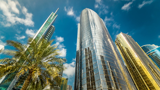 underside panoramic and perspective view to steel glass high rise building skyscrapers timelapse hyperlapse, business concept of successful industrial architecture, Dubai, UAE. Blue cloudy sky at sunny day