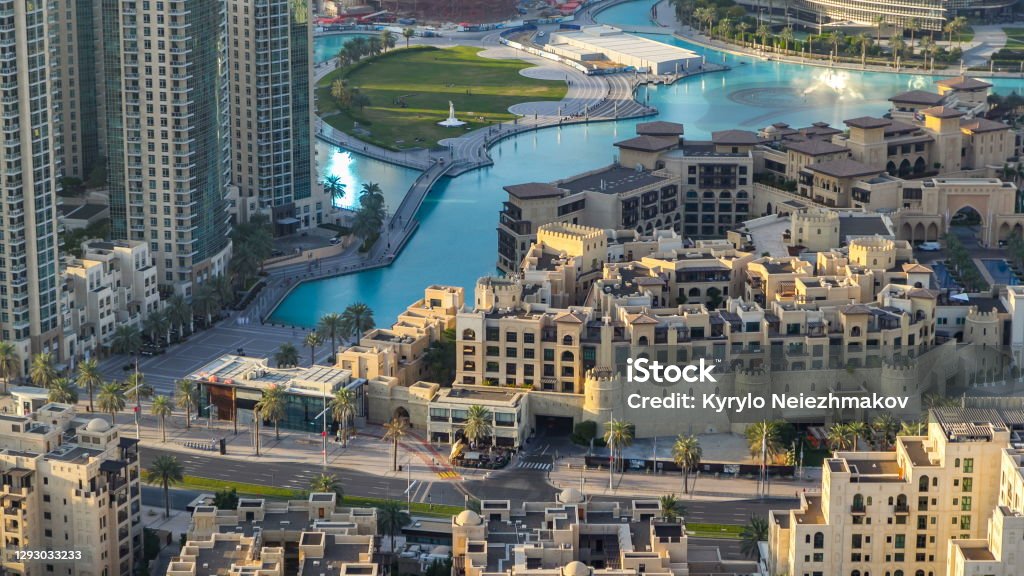 Top view of the bridge over man-made lake timelapse in Dubai downtown, United Arab Emirates Top close up view of the bridge over man-made lake and some people walking in park with hand monument timelapse in Dubai downtown before sunset, United Arab Emirates. It is located in Burj Khalifa complex near Mall. Dubai Stock Photo