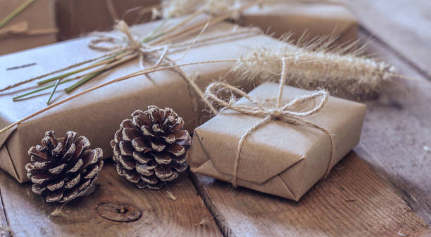 istock Christmas gift box Use brown recycled paper and notepad on a wooden table. 1293035530