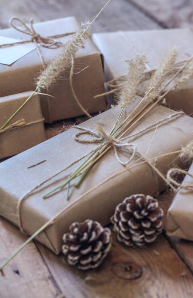 istock Christmas gift box Use brown recycled paper and notepad on a wooden table. 1293035542