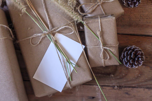 istock Christmas gift box Use brown recycled paper and notepad on a wooden table. 1293035543
