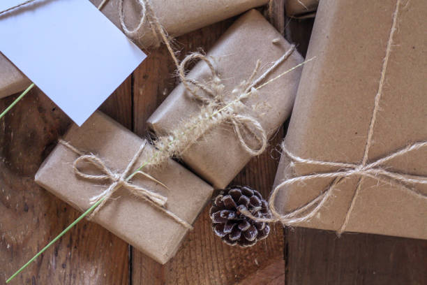 istock Christmas gift box Use brown recycled paper and notepad on a wooden table. 1293035549