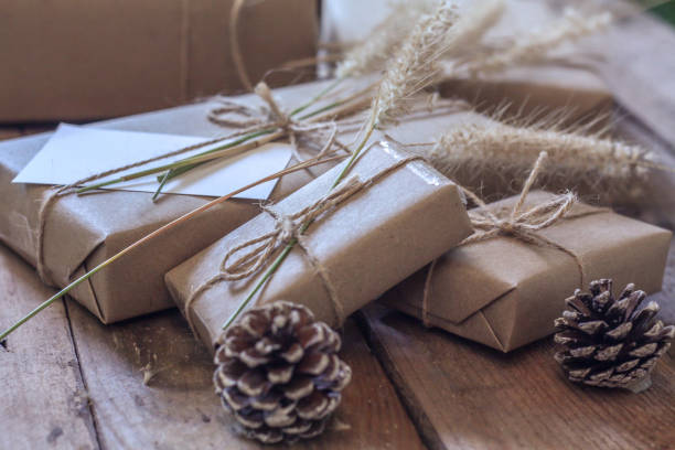 istock Christmas gift box Use brown recycled paper and notepad on a wooden table. 1293035553